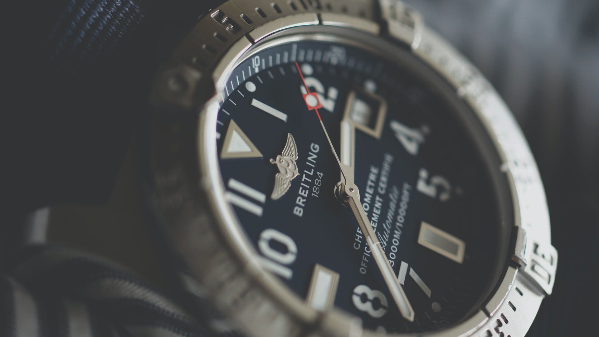 close up of breitling watch on dark background